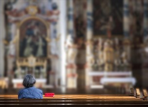 Senior woman sitting alone in a church