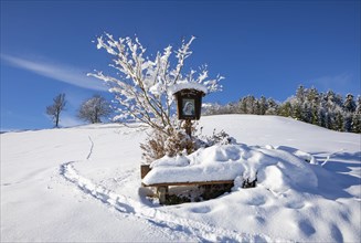 Snow-covered wayside shrine in Mondseeland