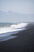 Black sandy beach by the sea