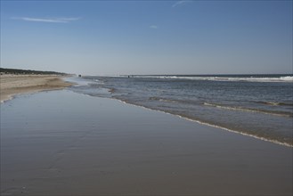 Long sandy beach with outgoing waves