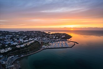 View over Torquay and Torquay Marina from a drone in sunrise time