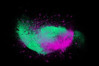 Freeze motion of colorful powder paint exploding isolated on black dark background. Abstract design of color dust cloud. Particles explosion screen saver