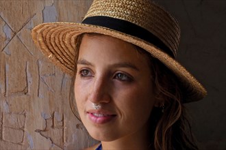 Young woman with straw hat and nose piercing sweats