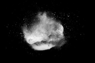 Freeze motion of white powder paint exploding isolated on black