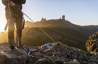 Man with professional gear doing rappelling sport in beautiful scenery of Roque Nublo mountain