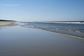 Long sandy beach with outgoing waves