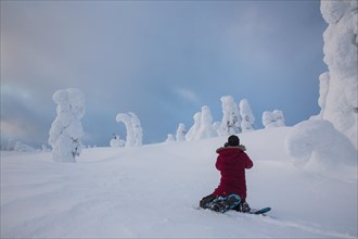 Photographer taking pictures of icy trees in Riisitunturi National Park