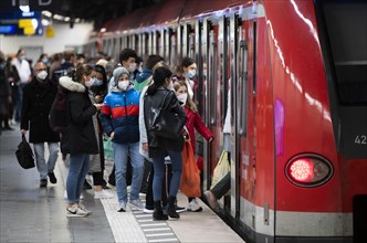 Group of people wearing face masks boarding the S-Bahn at Marienplatz station