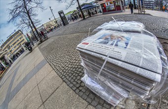 Piles of daily newspapers on the pavement