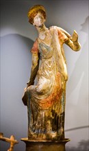 Female ceramic statuette unknotting her boot