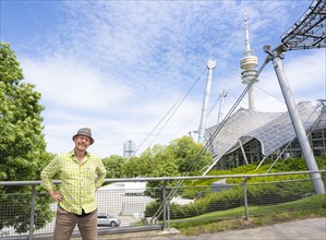 Friendly smiling man at the Olympic tower with Olympic tent roof