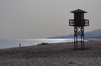 Watchtower on the beach against the light