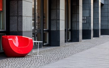 Red designer armchair on the street
