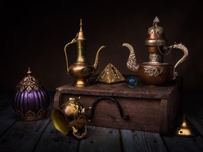 Still life with oriental jug and gilded pyramid on wooden box