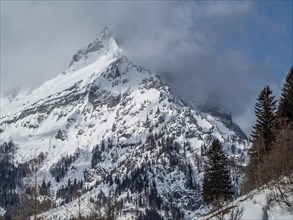 Snow-covered ridge in clouds