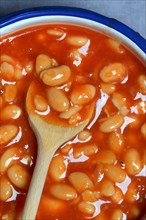 White beans with tomato sauce and cooking spoon