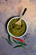 Green Thai curry paste in bowl and chillies
