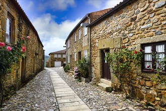 Narrow street with flowers and old stone houses