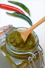 Green Thai curry paste in jar and chillies