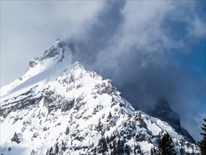 Snow-covered ridge in clouds
