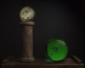 Still life with glass balls and wooden spool