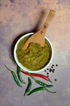 Green Thai curry paste in bowl and chillies