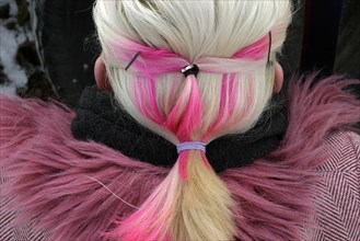Blonde woman with pink hair and coat with pink fur collar