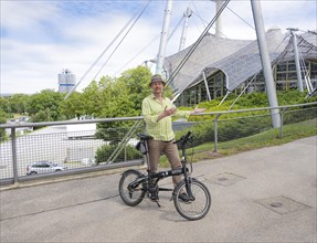 Man with bicycle on the Olympic tent roof