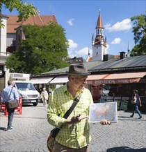 Tour guide with city map on city tour at the Viktualienmarkt
