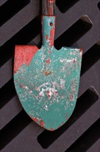 Shovel used to stir paint lies on drain grate of manhole