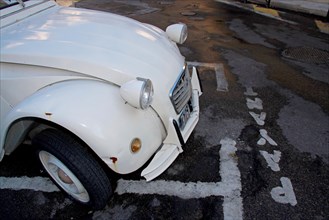 Side view of the front of a white Citroen 2CV in a car park
