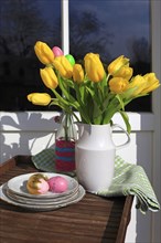 Bouquet of tulips and Easter eggs on a balcony