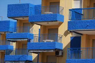 Blue balconies of a hotel complex with white-blue awnings