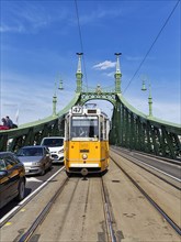Yellow tram driving through bridge gate
