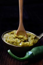 Thai green curry paste in ladle and chilli pepper