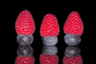 Three raspberries and three blueberries mirroring each other