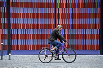 Cyclist in front of the colourful striped facade of the Brandhorst Museum