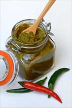Green Thai curry paste in jar and chillies