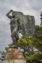 Statue and monument of Spyros Kayales with Greek flag