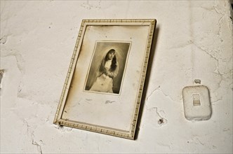 Framed photo on white wall of girl at communion