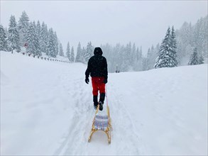 Man pulling a sledge through the snow