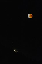 Lunar eclipse over the mountain station of the Saentisbahn