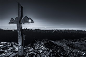 Backlit summit cross of the Lyfispitze
