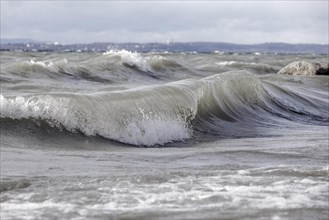 Storm Lolita raging on the rocky shore with waves in Hagnau
