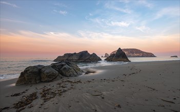 Sandy beach beach Harris Beach with rocks at sunrise