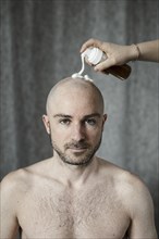 Man gets shaving foam sprayed on his bald head