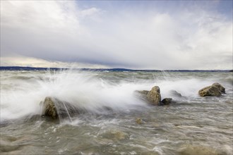 Storm Lolita raging on the rocky shore with waves in Hagnau