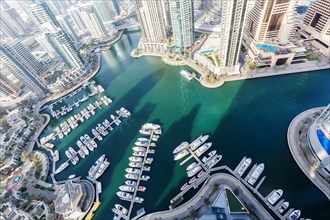 Dubai Marina and Harbour luxury wealth holiday with boats yacht from above in Dubai