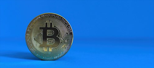 Bitcoin BTC crypto currency gold coin on blue background