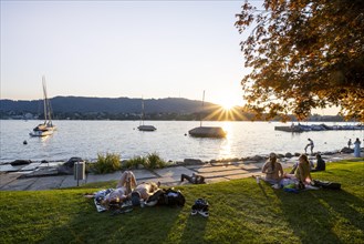 People sunbathing on the shore of Lake Zurich